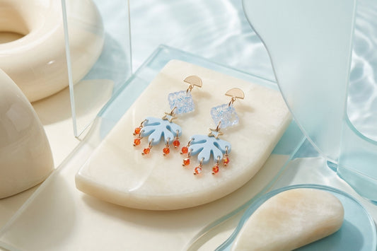 Blue Alba acrylic statement dangle earrings in a styled product setting