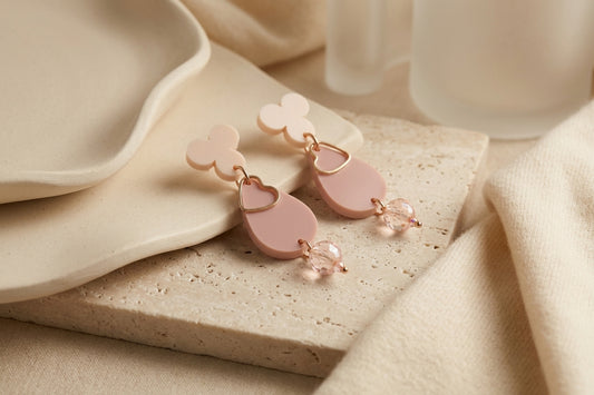 Beige Ana teardrop acrylic dangle earrings in a styled product setting