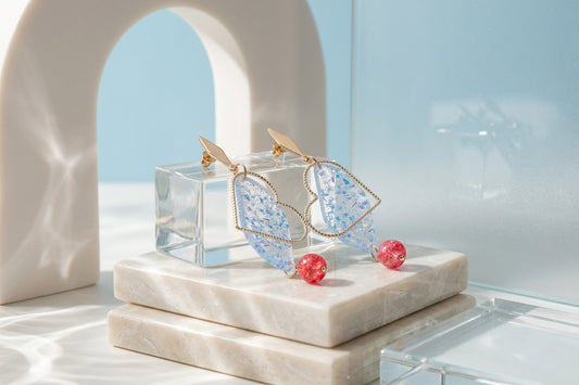 Blue Elise long heart dangle earrings in a styled product setting
