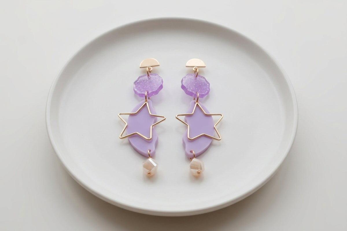 Purple Sara long star dangle earrings arranged on a white plate