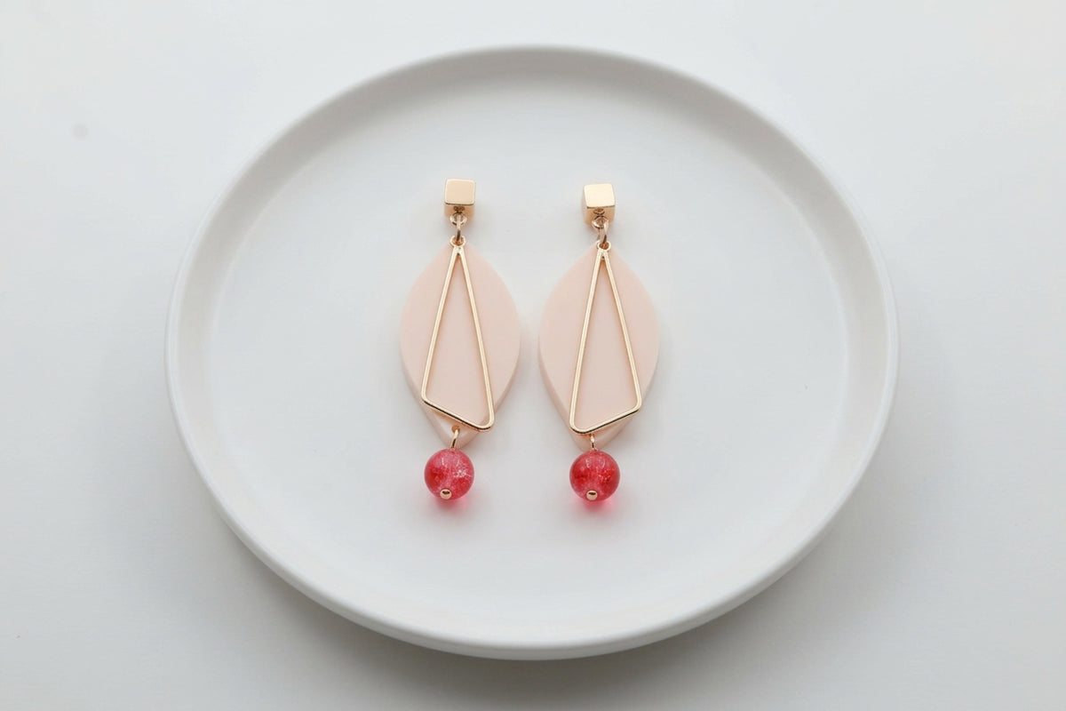 Beige Ada geometric acrylic statement earrings arranged on a white plate