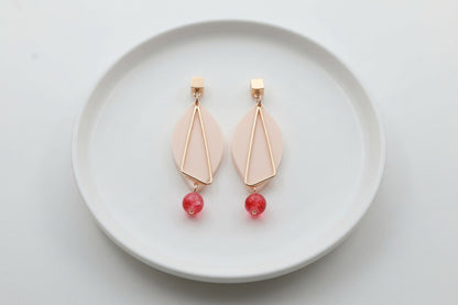 Beige Ada geometric acrylic statement earrings arranged on a white plate