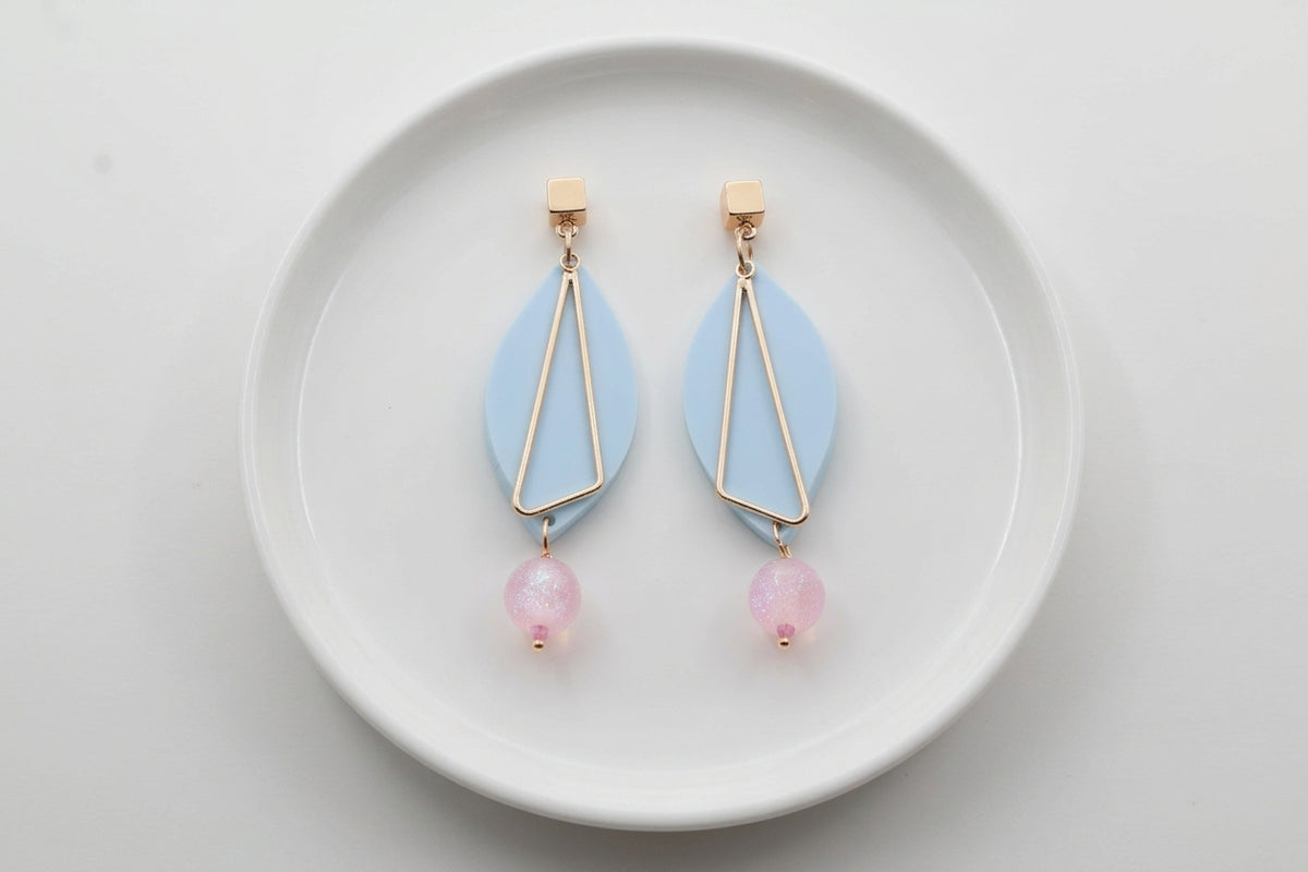Blue Ada geometric acrylic statement earrings arranged on a white plate