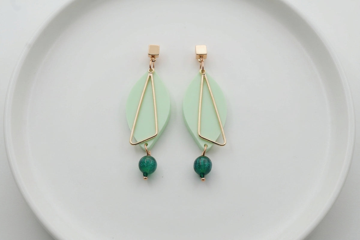 Green Ada geometric acrylic statement earrings arranged on a white plate