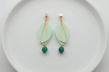 Green Ada geometric acrylic statement earrings arranged on a white plate
