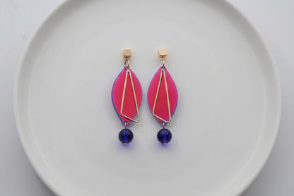 HB Ada geometric acrylic statement earrings arranged on a white plate