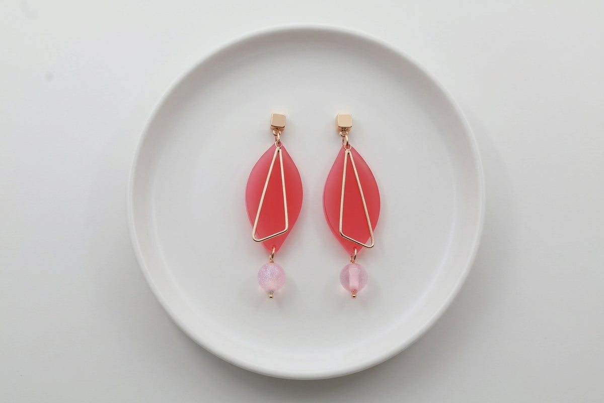 Pink Ada geometric acrylic statement earrings arranged on a white plate
