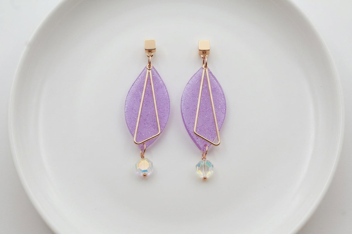 Purple Ada geometric acrylic statement earrings arranged on a white plate