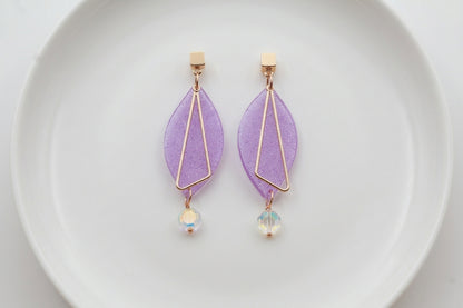Purple Ada geometric acrylic statement earrings arranged on a white plate