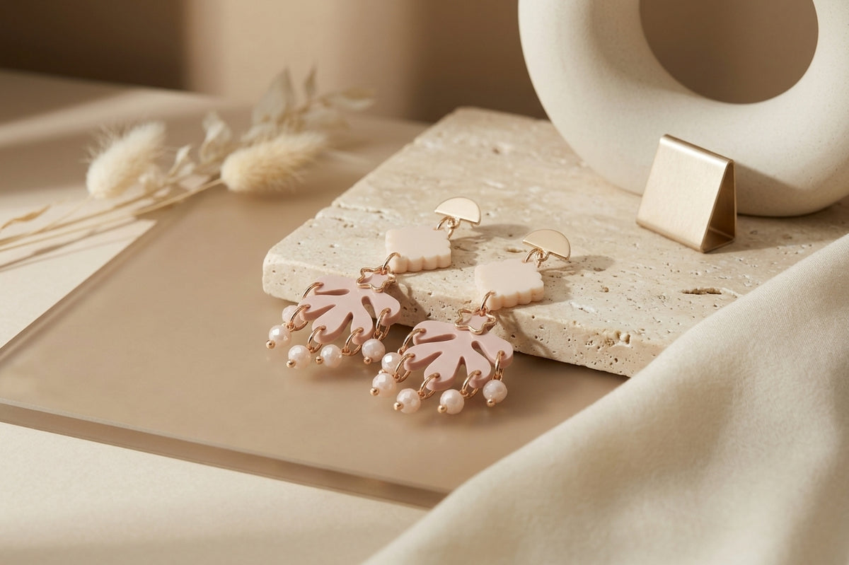 Beige Alba acrylic statement dangle earrings in a styled product setting