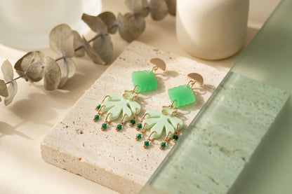 Green Alba acrylic statement dangle earrings in a styled product setting