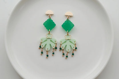 Green Alba acrylic statement dangle earrings arranged on a white plate