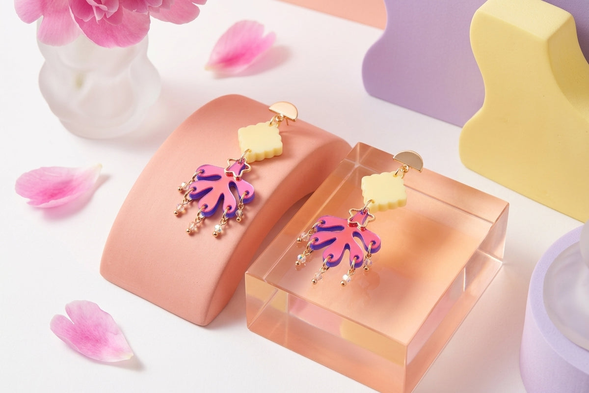HB Alba acrylic statement dangle earrings in a styled product setting