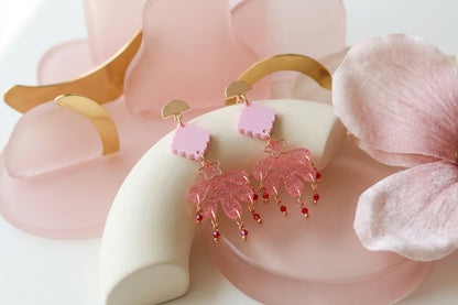 Pink Alba acrylic statement dangle earrings in a styled product setting