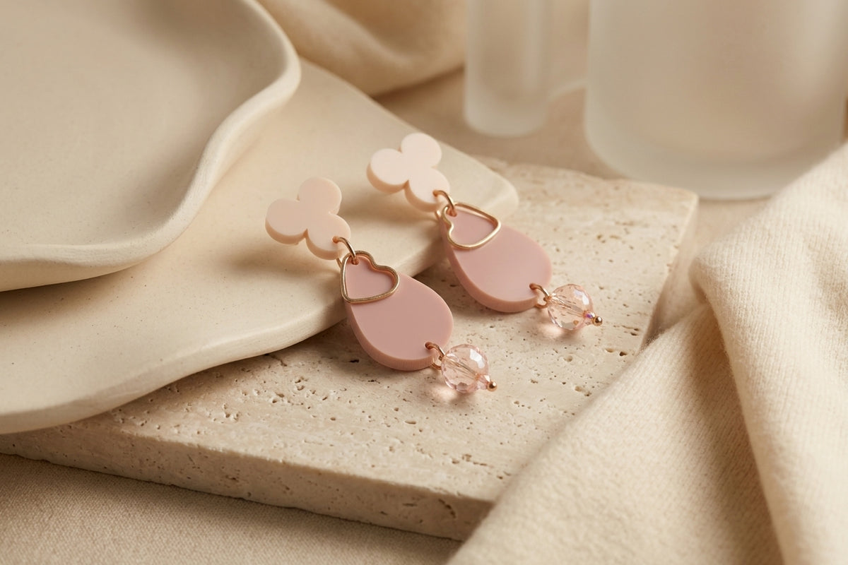 Beige Ana teardrop acrylic dangle earrings in a styled product setting