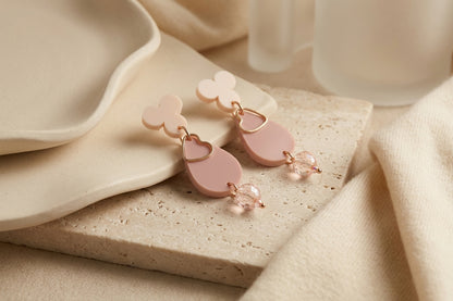 Beige Ana teardrop acrylic dangle earrings in a styled product setting
