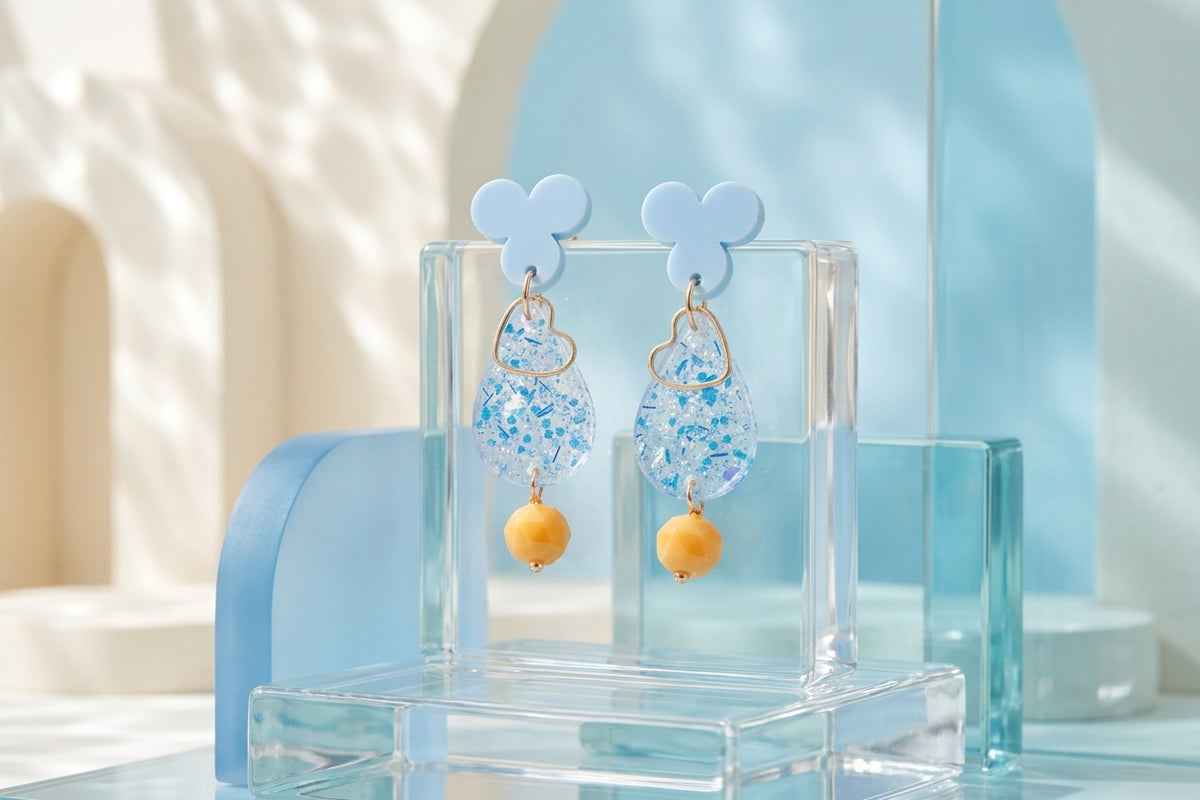 Blue Ana teardrop acrylic dangle earrings in a styled product setting