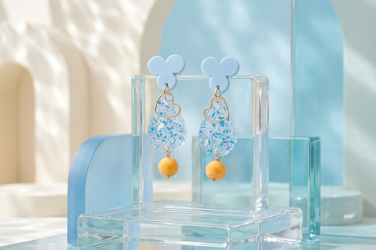 Blue Ana teardrop acrylic dangle earrings in a styled product setting