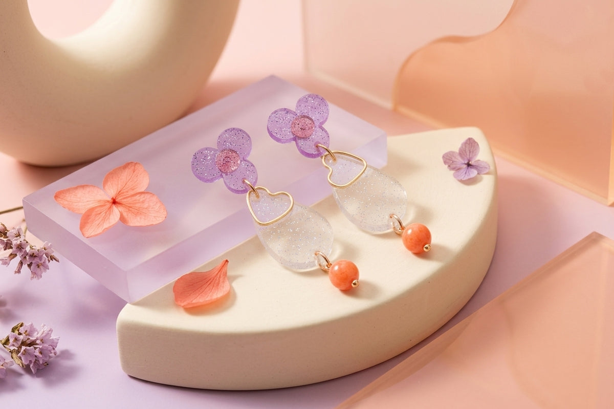 Purple Ana teardrop acrylic dangle earrings in a styled product setting