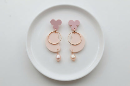Beige Ayla modern acrylic statement earrings arranged on a white plate