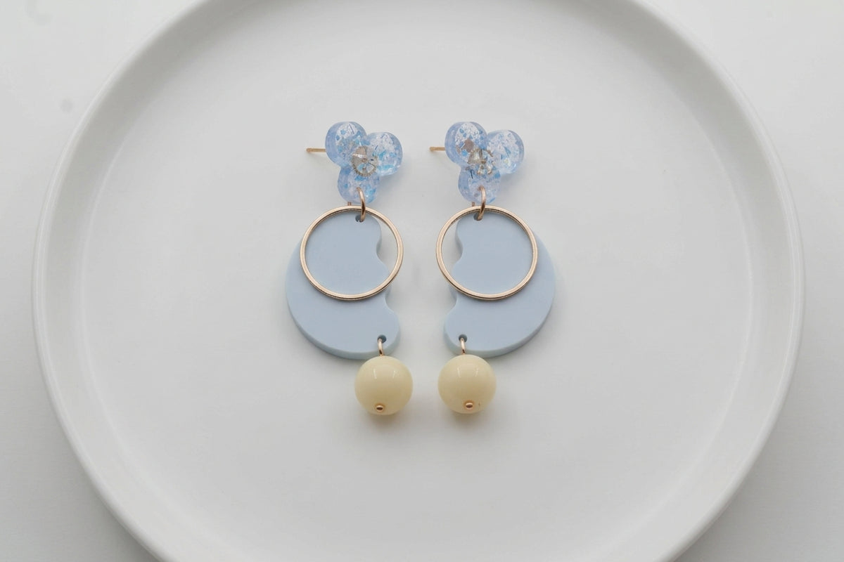 Blue Ayla modern acrylic statement earrings arranged on a white plate