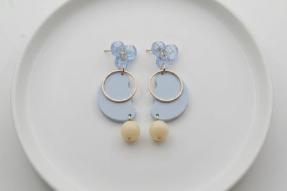 Blue Ayla modern acrylic statement earrings arranged on a white plate