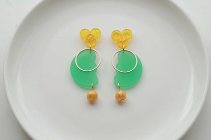 Green Ayla modern acrylic statement earrings arranged on a white plate