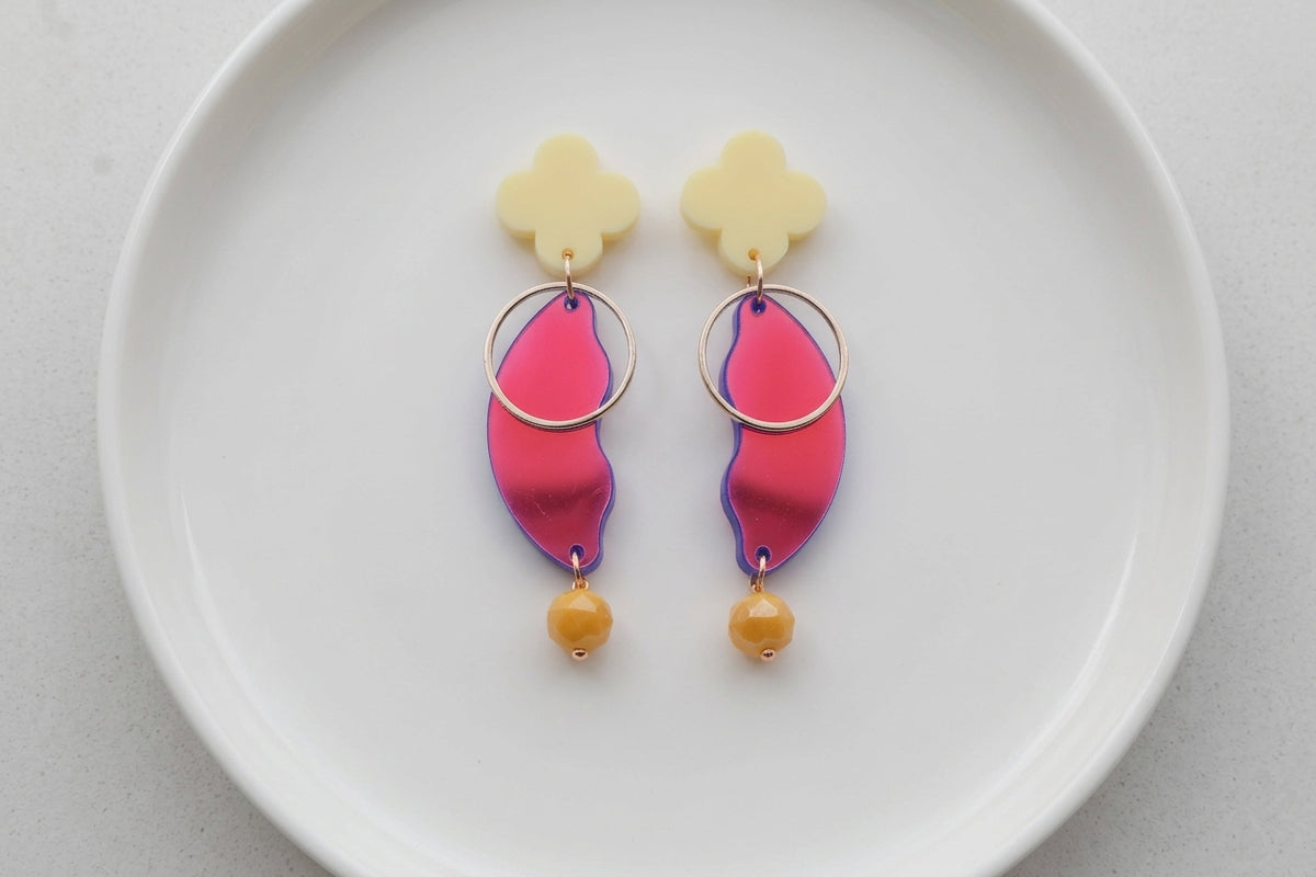 HB Ayla modern acrylic statement earrings arranged on a white plate