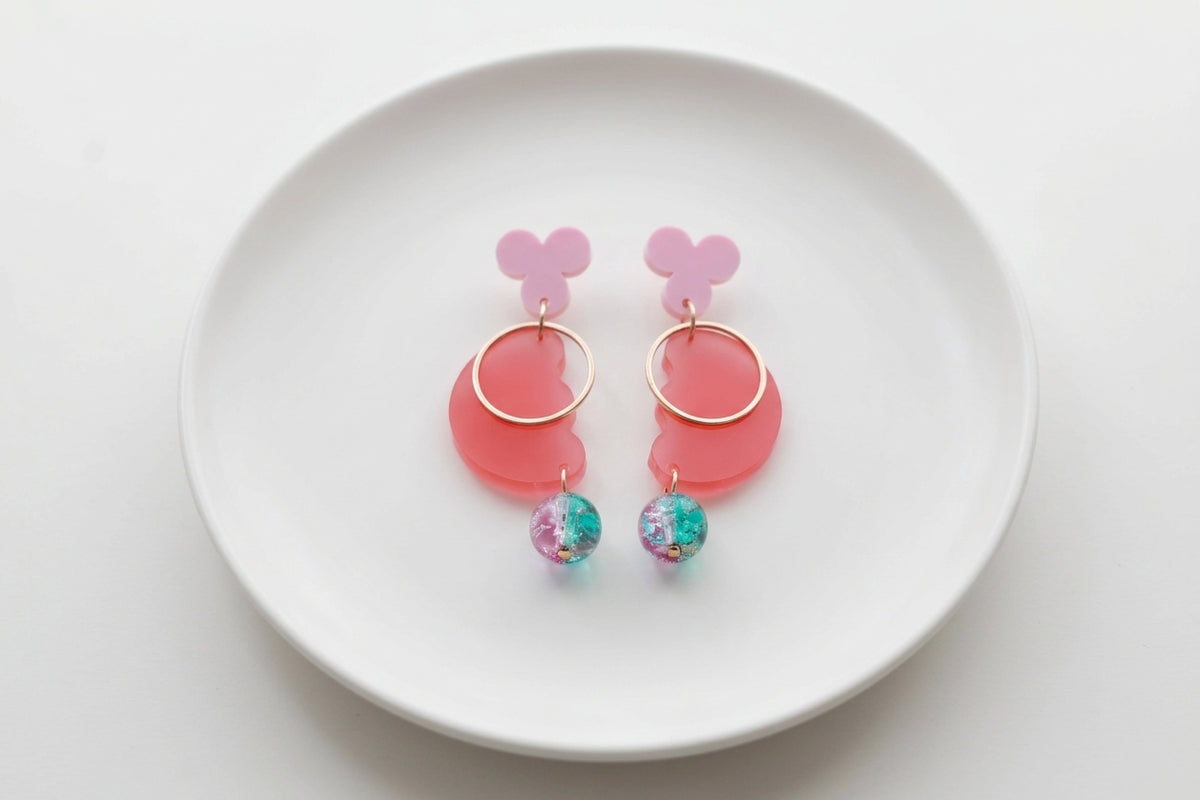Pink Ayla modern acrylic statement earrings arranged on a white plate