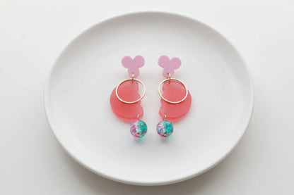 Pink Ayla modern acrylic statement earrings arranged on a white plate