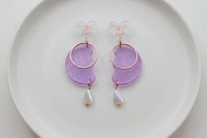 Purple Ayla modern acrylic statement earrings arranged on a white plate
