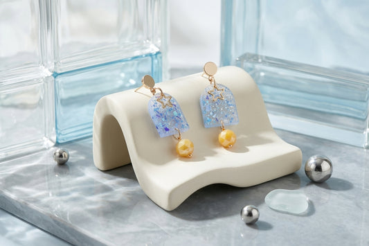 Blue Eira star acrylic drop earrings in a styled product setting