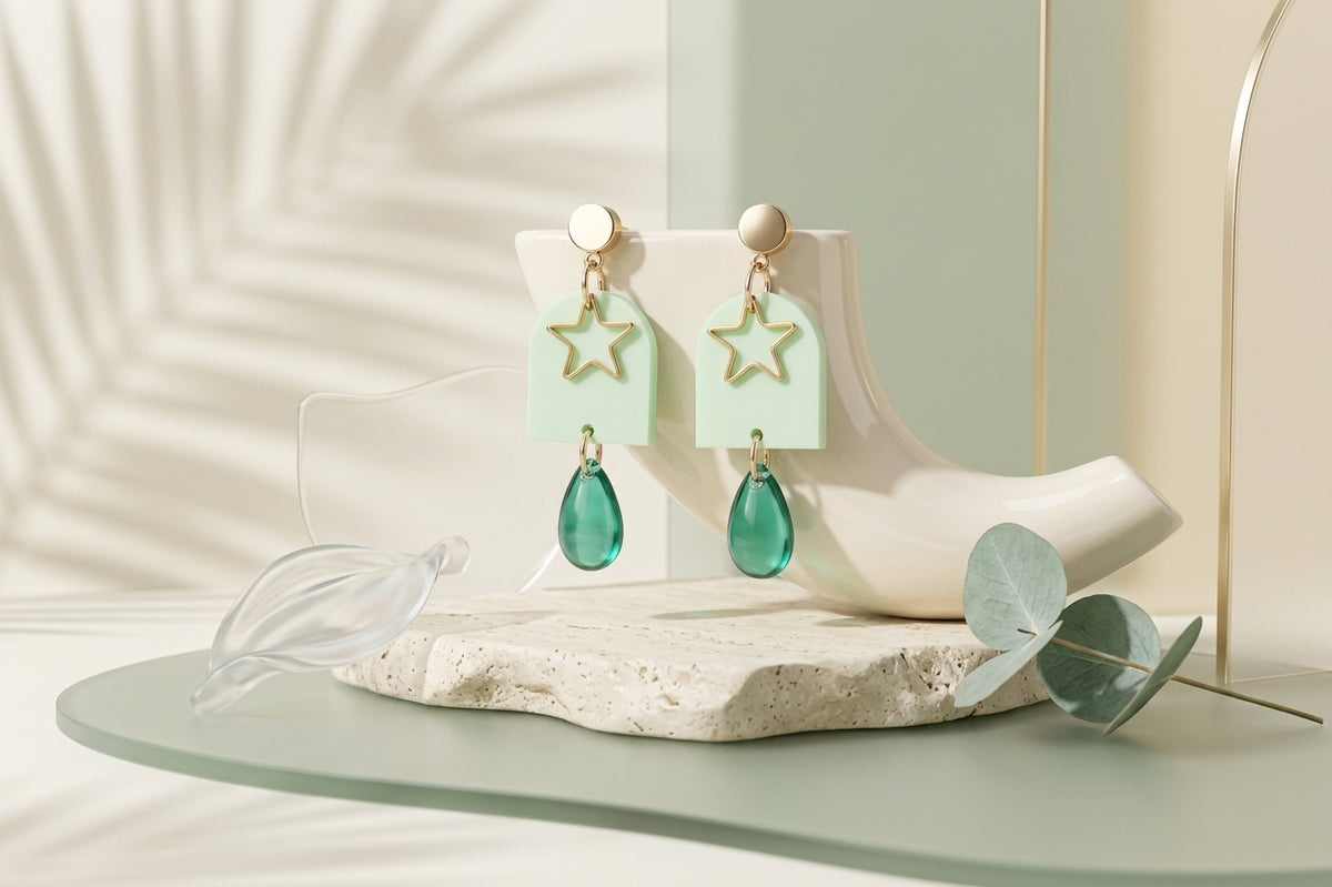 Green Eira star acrylic drop earrings in a styled product setting