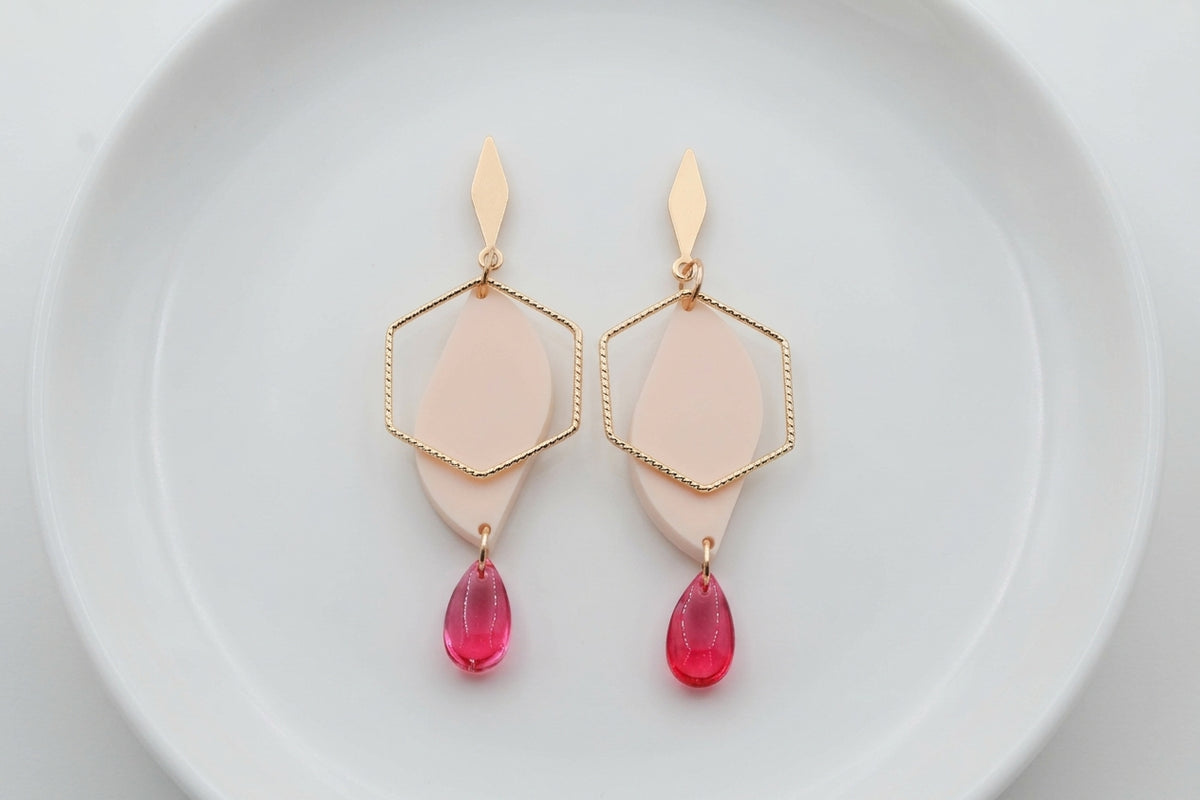 Beige Elise long heart dangle earrings arranged on a white plate