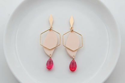 Beige Elise long heart dangle earrings arranged on a white plate
