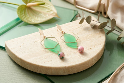 Green Elise long heart dangle earrings in a styled product setting