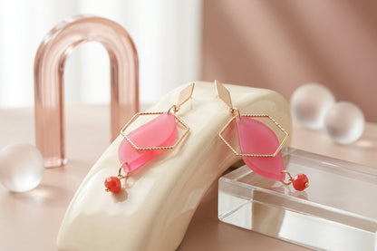 Pink Elise long heart dangle earrings in a styled product setting