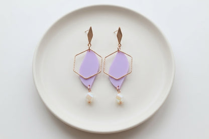 Purple Elise long heart dangle earrings arranged on a white plate