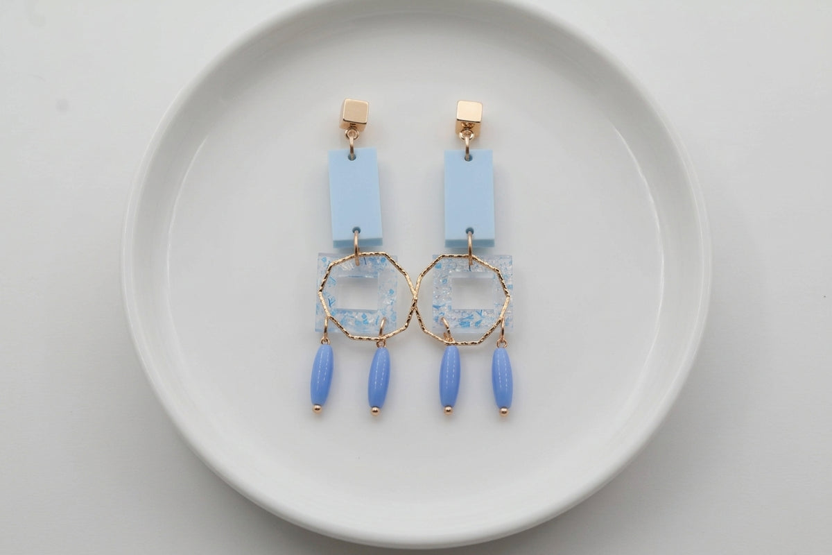 Blue Ella geometric rectangle drop earrings arranged on a white plate