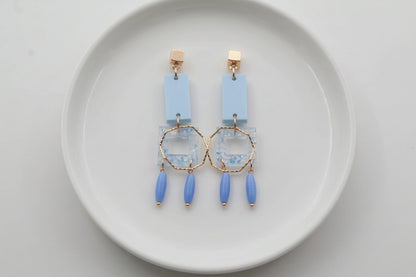 Blue Ella geometric rectangle drop earrings arranged on a white plate