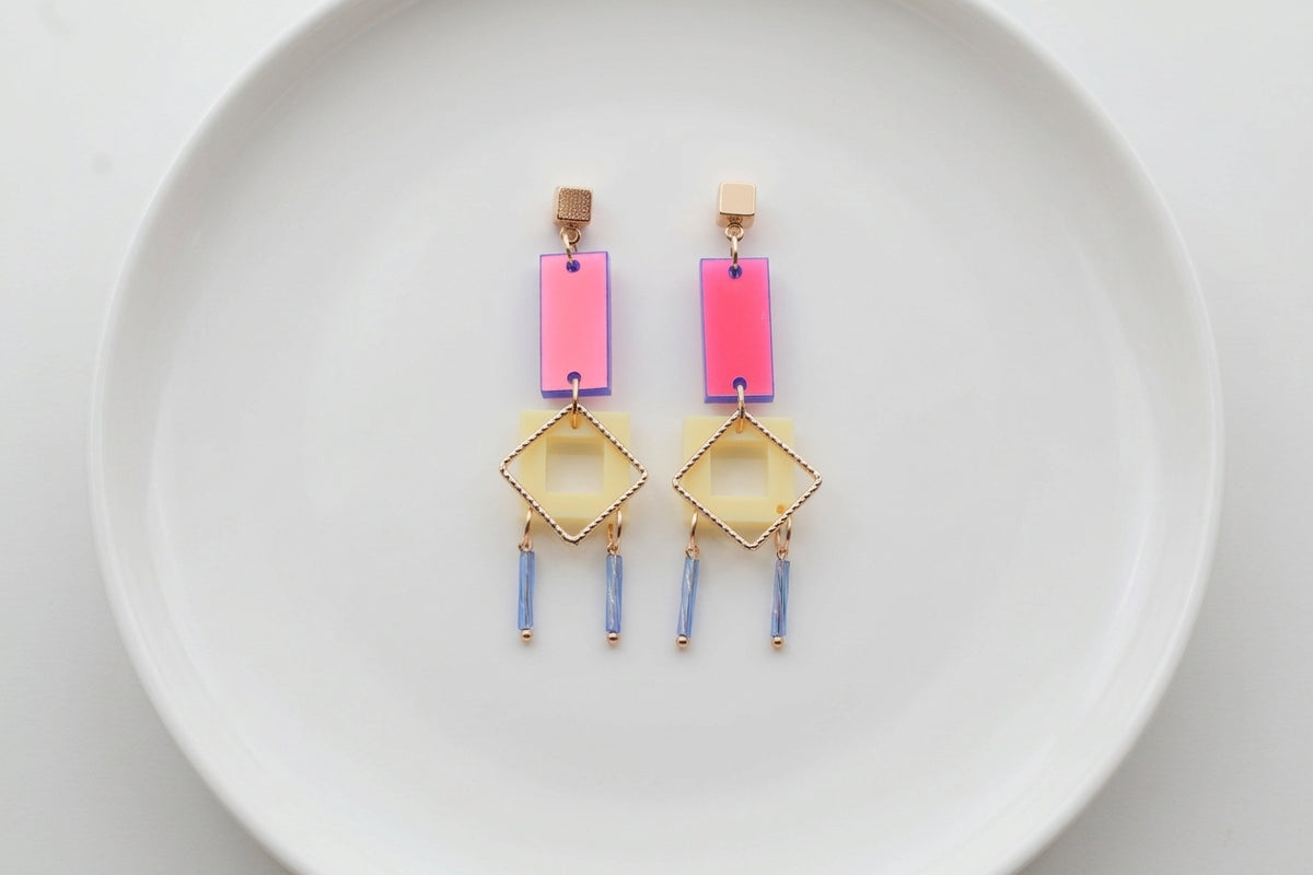 HB Ella geometric rectangle drop earrings arranged on a white plate