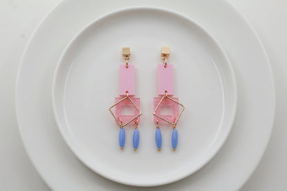 Pink Ella geometric rectangle drop earrings arranged on a white plate