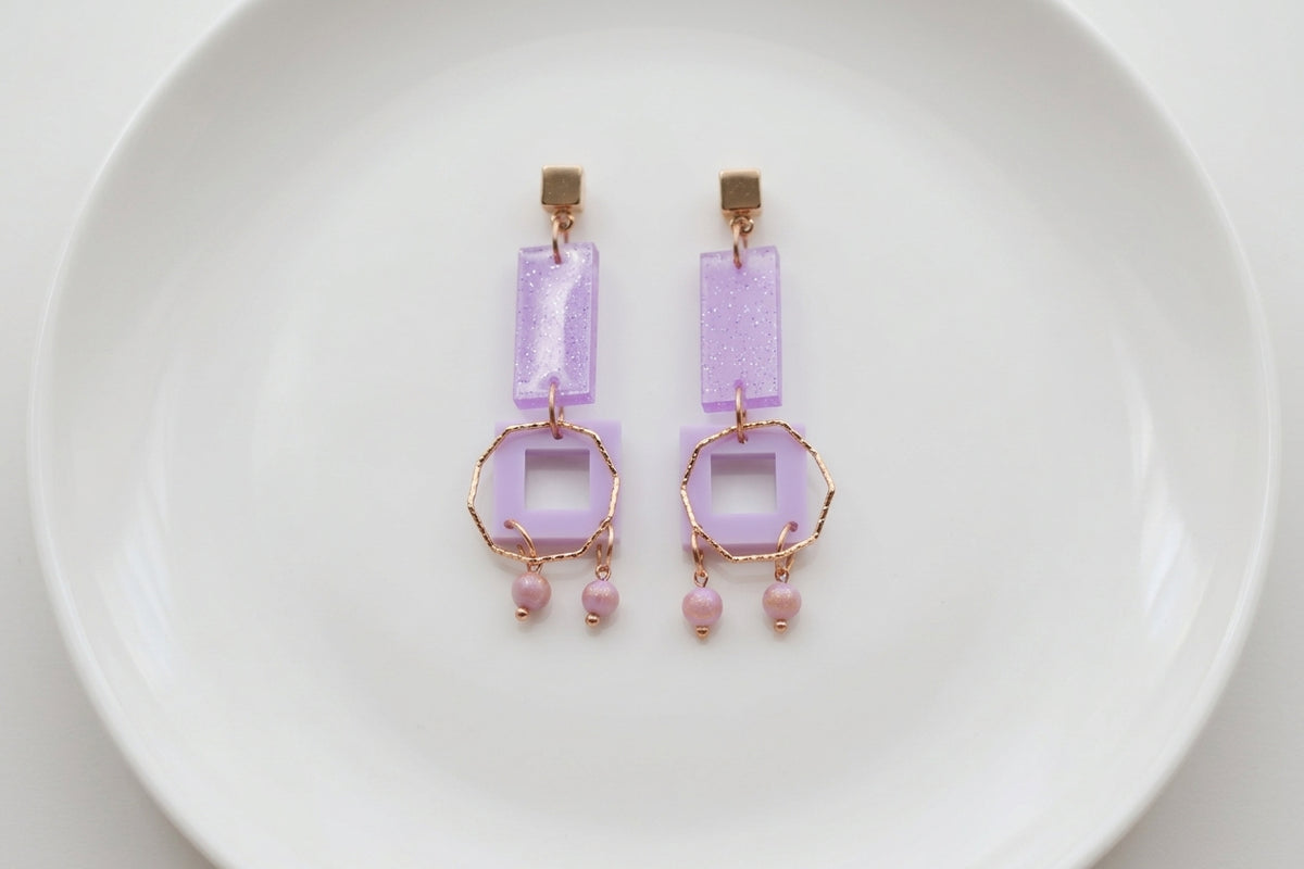 Purple Ella geometric rectangle drop earrings arranged on a white plate