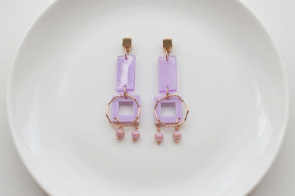 Purple Ella geometric rectangle drop earrings arranged on a white plate