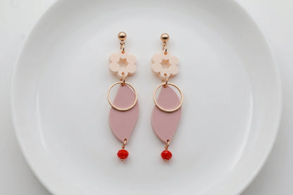 Beige Elsa floral long dangle earrings arranged on a white plate