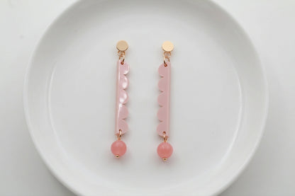 Beige Emma long geometric acrylic earrings arranged on a white plate