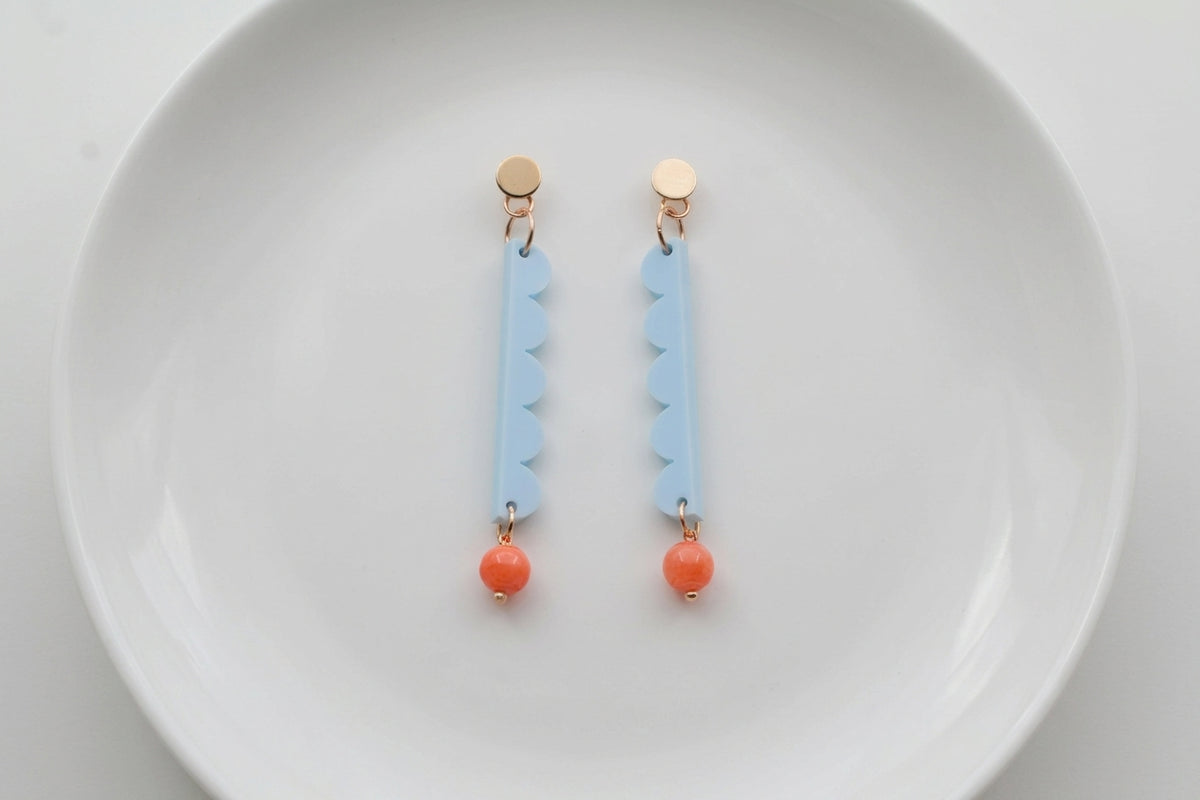 Blue Emma long geometric acrylic earrings arranged on a white plate