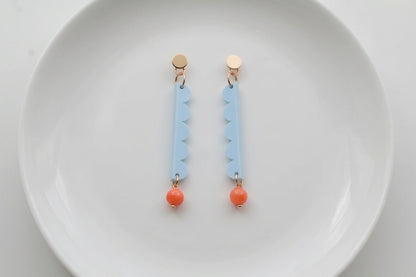 Blue Emma long geometric acrylic earrings arranged on a white plate