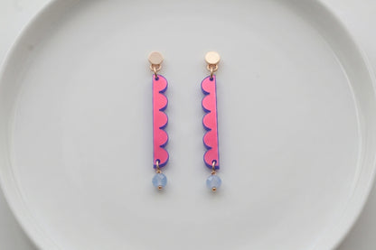 HB Emma long geometric acrylic earrings arranged on a white plate