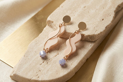 Beige Esme long acrylic statement earrings in a styled product setting